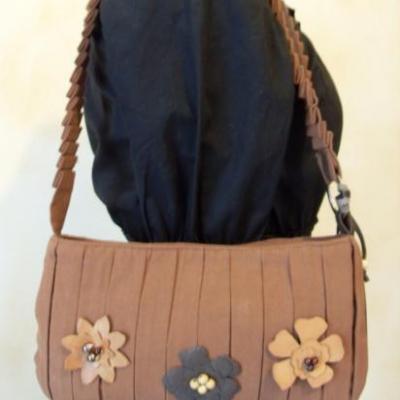 Sac à main marron et fleurs en cuir.