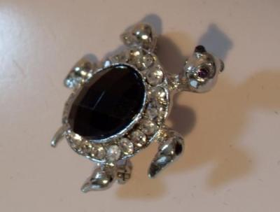 Broche tortue argentée et strass noir.