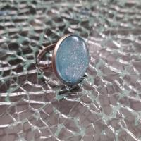 Bague ronde, cabochon de verre bleu et paillettes.