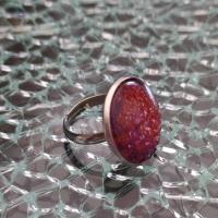 Bague ronde, cabochon de verre prune et paillettes.