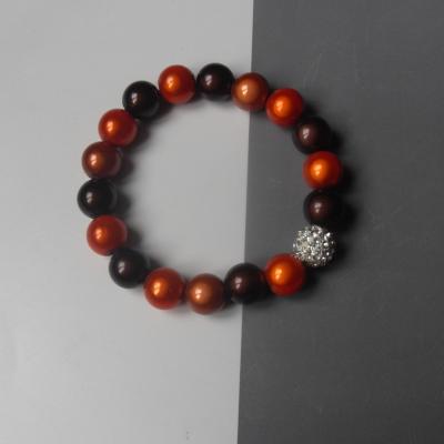 Bracelet marron et orange, perles magiques et strass blanc.