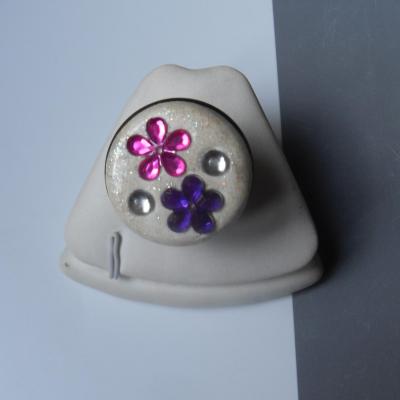 Bague ronde, gros cabochon blanc pailleté et fleurs strass rose-violet.