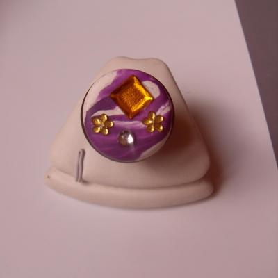 Bague ronde, gros cabochon blanc-violet, carré orange et fleurs strass.