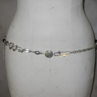 Ceinture-bijou, chaîne-maillons, grosse perle noire, épingles et strass.