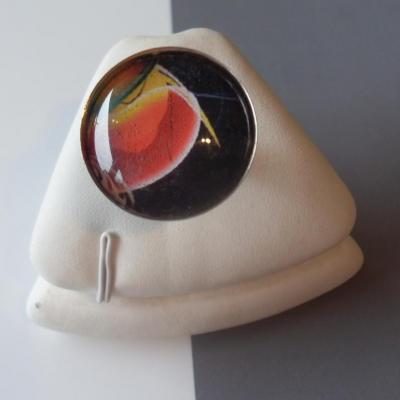 Bague ronde, gros cabochon de verre et motifs.